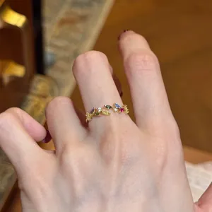 Close-up detail of a vintage style open ring with vibrant multi-colored zircon leaf design