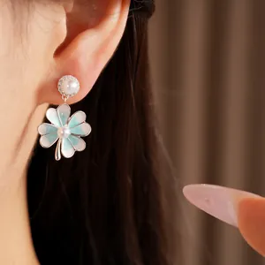 Detailed view of an elegant blue enamel four-leaf clover earring with pearls and zircons