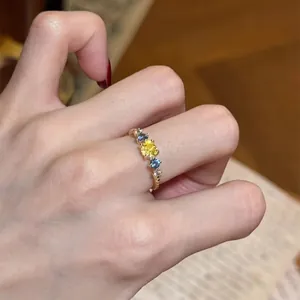 Macro shot of an elegant gold-tone ring featuring vibrant yellow and blue zircon stones