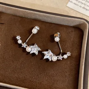 Close-up of star-shaped cubic zirconia earrings with delicate pearl accents