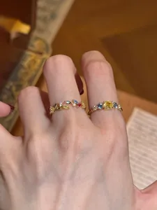 Detailed macro shot of vintage-style colorful zircon leaf open rings on a finger