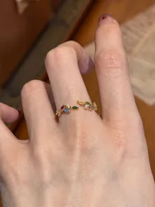 Detailed view of a golden vintage open ring featuring multi-color leaf zircons