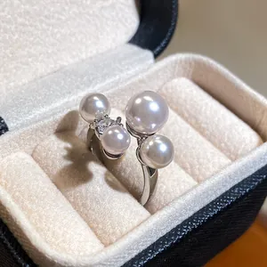 Detailed macro view of an elegant open ring featuring lustrous pearls and a zircon stone.