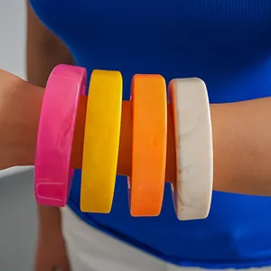 Detaillierte Nahaufnahme von bunten Harz-Armreifen im Dopamin-Stil am Arm eines Models