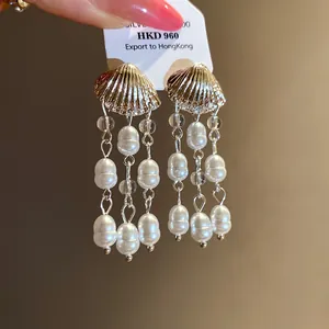Detail view of vintage seashell stud earrings featuring elegant white pearl tassel drops