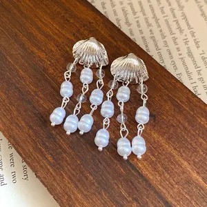 Detailed view of silver shell stud earrings with elegant faux pearl tassel drops.