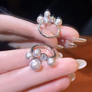 Detailed view of an elegant French retro open ring with pearls and sparkling zircon