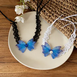 Detail view of lace butterfly chokers with blue wings and elegant pearl accents