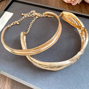 Detail view showing texture of vintage gold metallic wrinkled and smooth chokers.