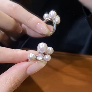 Macro detail view of a vintage zircon and pearl open ring showing elegant luster