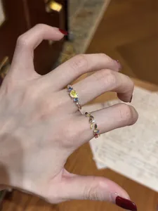 Macro detail view of vintage dopamine multi-colored zirconia leaf open rings on hand