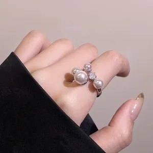 Close-up detail of an elegant silver ring featuring white pearls and a sparkling zircon center.