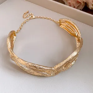 Close-up of vintage gold pleated twisted choker necklace with metal texture detail