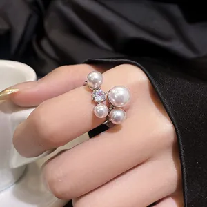 Detailed close-up of a retro silver ring featuring pearls and brilliant zircon on a finger