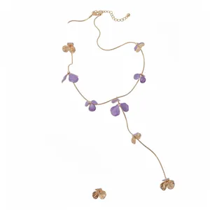 Elegant gold necklace featuring purple enamel flower petals in a stylish lariat design.