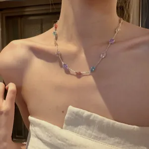 Vue détaillée d'un collier ras du cou délicat avec des zircons ronds multicolores
