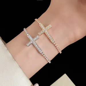 Primo piano dei braccialetti con croce incastonati di zirconi in oro e argento