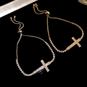 Dettaglio dei bracciali con croce in zircone oro e argento con catena regolabile