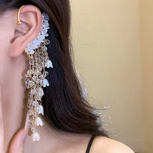 Detailansicht einer französischen Retro-Ohrmanschette mit Perlenblumen und langen Quasten