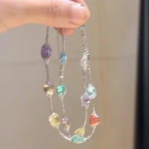 Détail des perles en zircone colorées sur un collier à chaîne argentée très fin