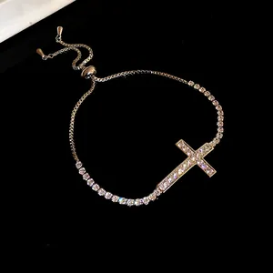 Vista dettagliata di un bracciale a croce dorato decorato con scintillanti pietre di zirconi