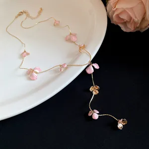 Close-up of elegant pink flower petal tassel necklace presented on a white ceramic plate