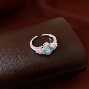 Vintage silver floral ring featuring a green center stone and sparkling zircon accents