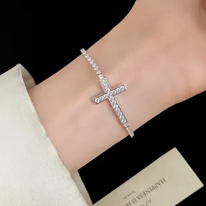 Elegante primo piano di un braccialetto a croce in zircone argento sul polso di una donna