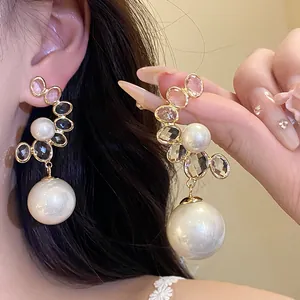 Dettaglio ravvicinato di orecchini vintage con perle e cristalli sfaccettati eleganti