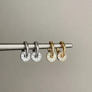 Detailed view of elegant zircon circular pendant hoop earrings in gold and silver tones.