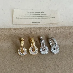 Detailed view of pavé zircon circular pendant earrings in gold and silver finish