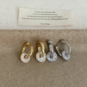 Detailed view of gold and silver zircon circular pendant hoop earrings with pavé setting