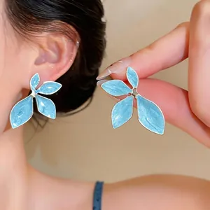 Light blue enamel flower stud earrings with elegant petal design and silver needles