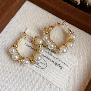 Vue détaillée de boucles d'oreilles créoles plaquées or 14 carats avec perles fines