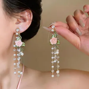 Close-up of elegant French style tassel earrings with pink rose and white pearls