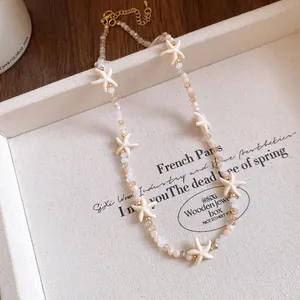 Close-up of a bohemian beaded necklace featuring elegant cream-colored starfish charms