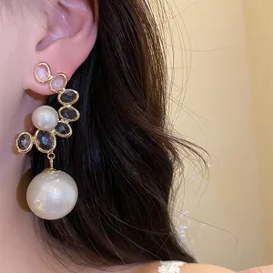 Primo piano di orecchino vintage elegante con perla e pietre nere su modella asiatica