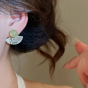 Primo piano di orecchino a forma di ventaglio con incisione di bambù e giada verde