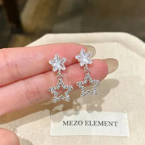 High-detail close-up of sparkling star-shaped earrings with a textured silver finish.