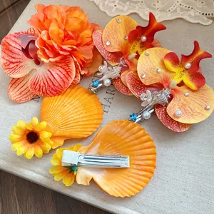 Detailed view of handmade fabric flower and shell hair clips with metal alligator grip