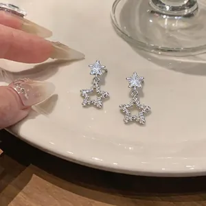 Close-up detail of Korean style silver star drop earrings with sparkling crystals