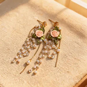Detail view of French style pink rose tassel earrings with pearls and crystals