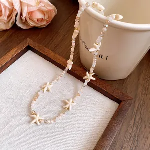 Detailed view of a bohemian beaded necklace with ivory starfish charms and crystals.