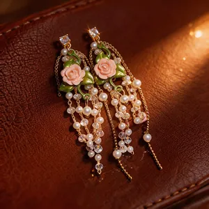 Elegant gold-tone tassel earrings with pink rose motifs, white pearls, and zircons