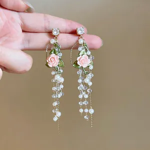 Detailed close-up view of French-style romantic pink rose drop earrings with pearls