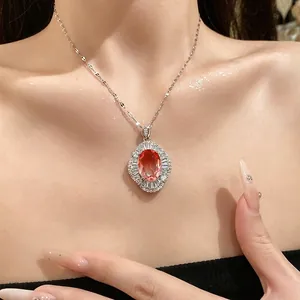 Elegante collar de plata con colgante ovalado de circonita naranja y halo de cristales