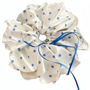 Grand chouchou en satin crème avec motif marguerites bleues et accessoire de nœud en ruban