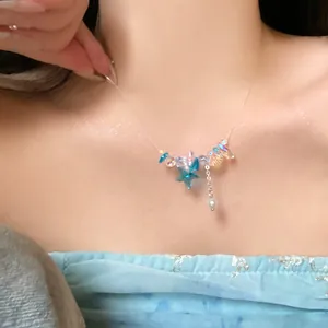 Elegante Halskette mit Seestern- und Perlenanhänger auf dem Dekolleté des Models mit Glitzer.