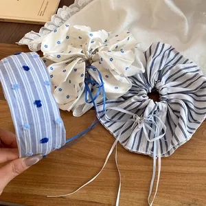 Détail d'accessoires de cheveux en tissu rayé, avec chouchous et serre-tête rembourré