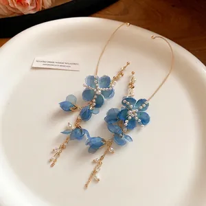 Earcuff romantici con fiori in chiffon blu, perle e nappe dorate su piatto